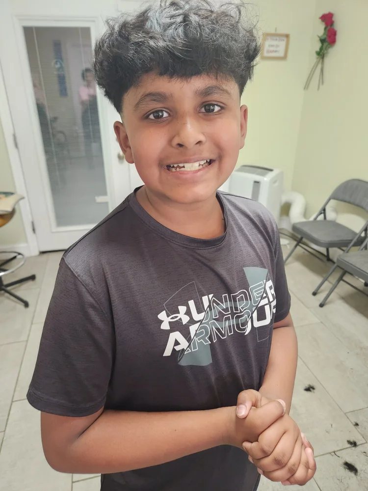 Smiling child after a haircut at Happy Barber