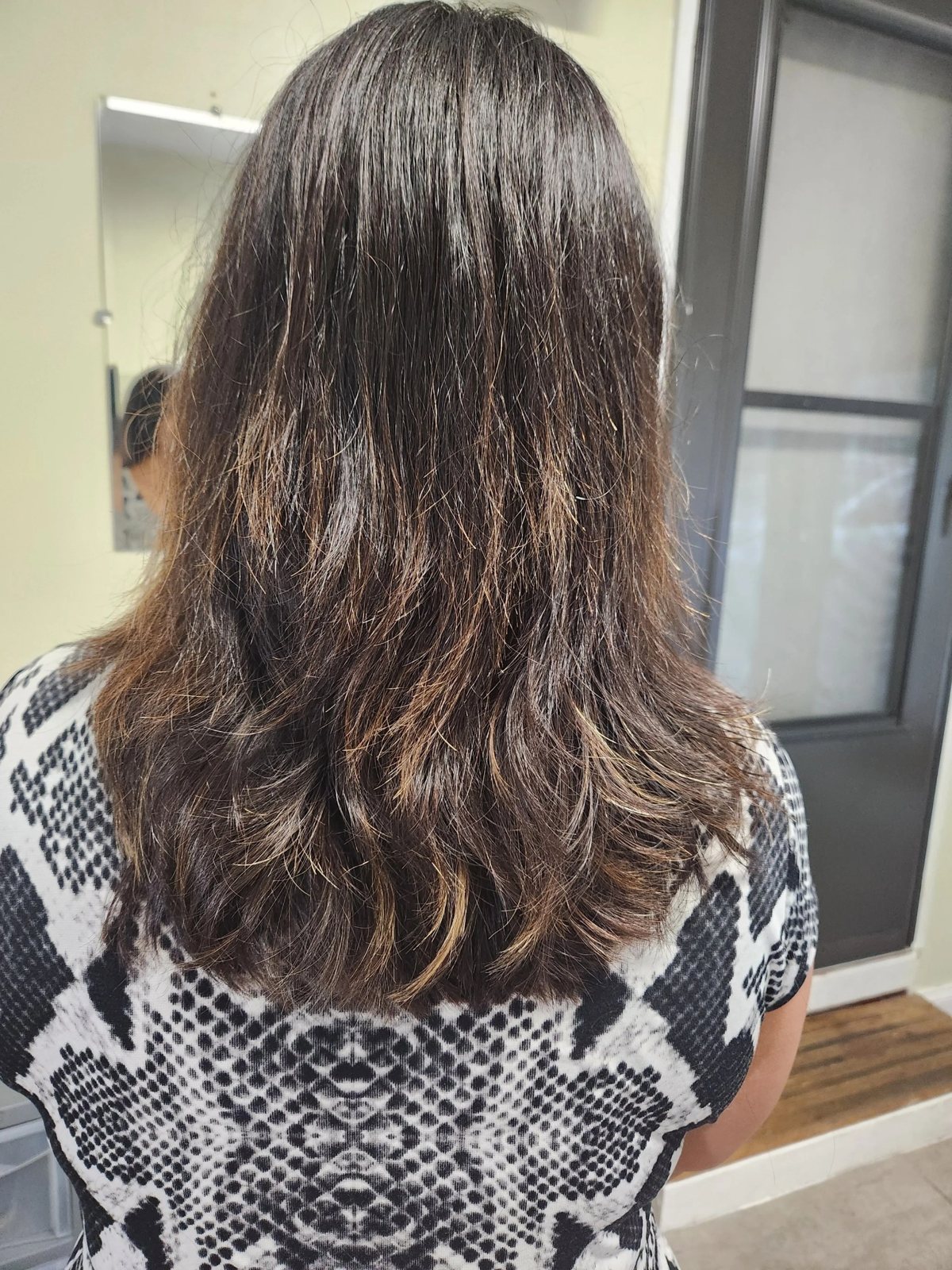 Women's layered haircut with soft highlights at Happy Barber